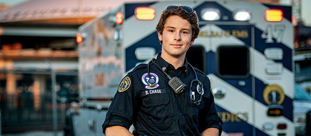 Photo of Brendan Chase in EMS uniform by ambulance