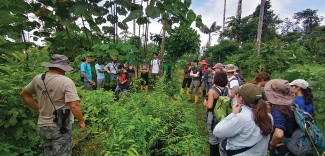 students learn from an FCAT researcher in the rainforest