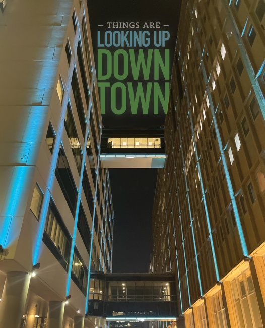 blue decorative lighting on two urban buildings, view looking up