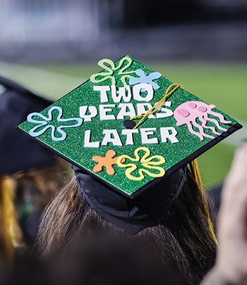 A decorated mortarboard says "two years later".