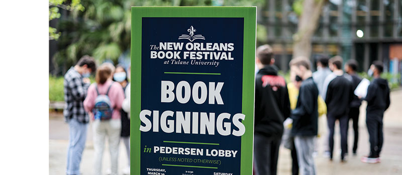 scenic photo of people near a book festival sign