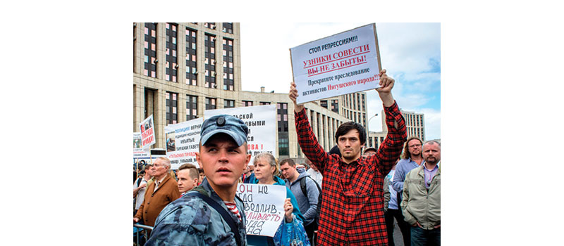 A group of people hold posters during a rally in defense of freedom of speech and journalism in central Moscow on  June 16, 2019.