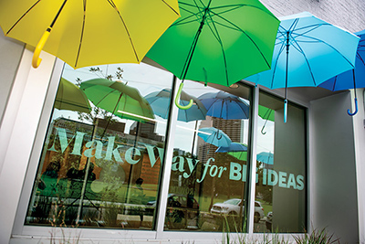 colorful umbrellas decorate the outside of a downtown building