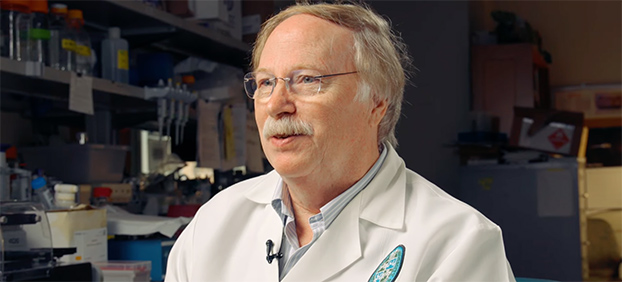 Robert Garry sitting in a lab surrounded by lab equipment