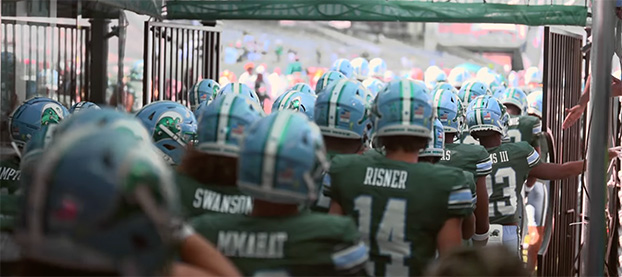 Tulane football players walking under the stadium tunnel to enter the field
