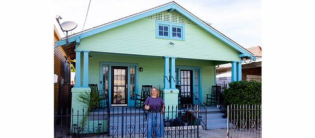 Robin S. Smith in front of light green New Orleans double style house