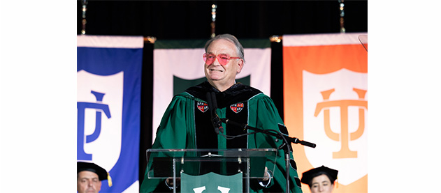 President Fitts in heart shaped sunglasses speaks to the Class of 2028