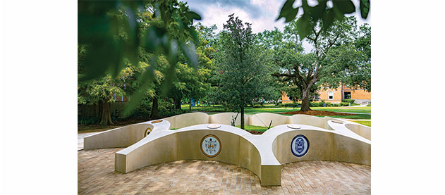 sculptural monument of nine plots nestled among trees 