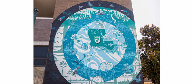 mural in blue, green and white concentric circles with Louisiana animals, plants, and instruments used in science