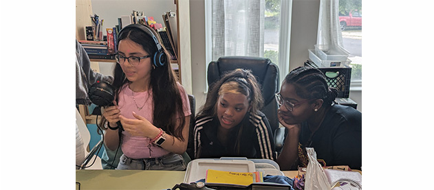 Camila Collazo Rivera mentors three middle school students as they record an announcement