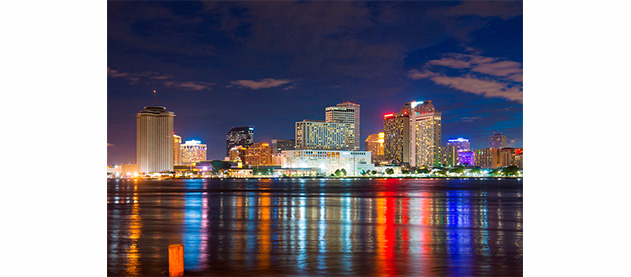 New Orleans skyline at night with light reflections on the river