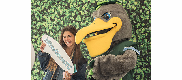 Tulane's mascot, Riptide and a woman pose for a photo
