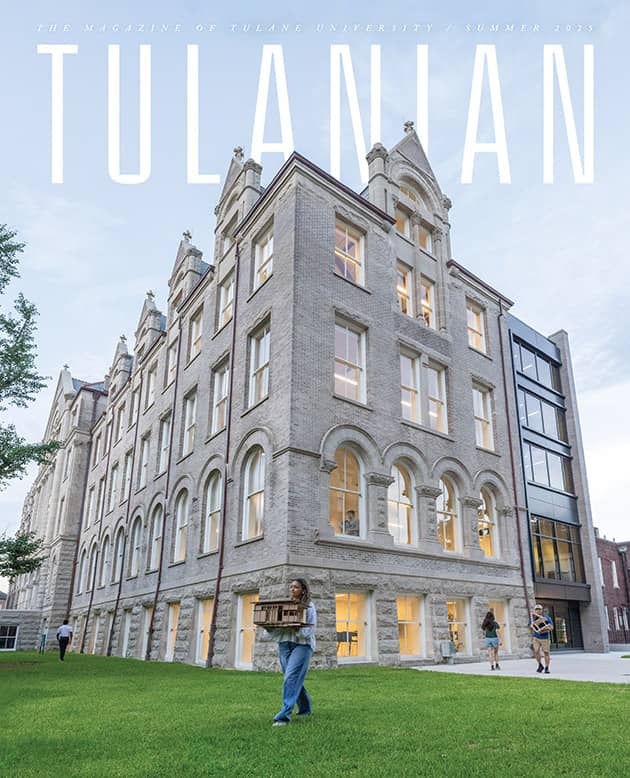 Cover of Tulanian magazine, Summer 2025 issue, featuring a tall, historic stone building on Tulane University’s campus at dusk. Warm light glows from the windows as students walk across the green lawn, including one carrying an architectural model.