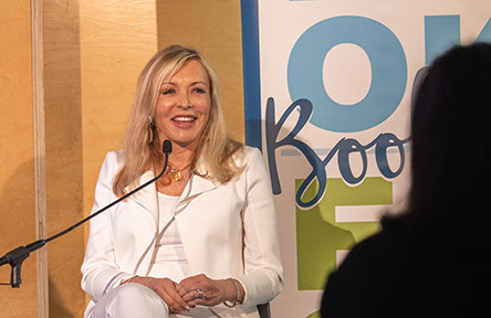 Marie Quintana speaks to audience while seated on the stage at Book Fest