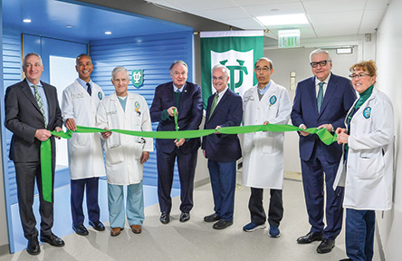 Eight medical professionals and administrators at a ribbon-cutting ceremony.