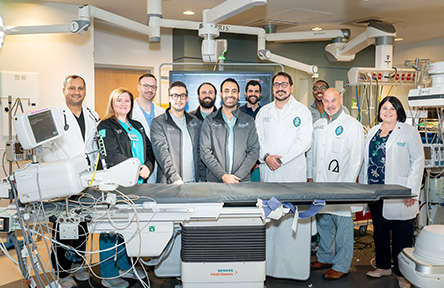 Photograph: medical professionals stand in a modern operating room.