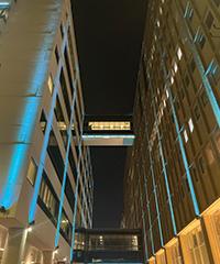 blue decorative lighting on two urban buildings, view looking up