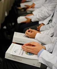 close up of medical students in white coats sitting in ceremony