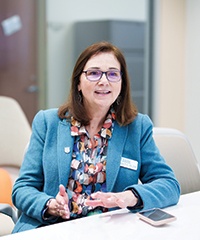 Brenda Douglas speaks while sitting at a conference table