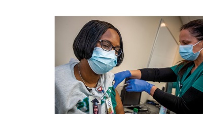 Nurse Giselle Salvant is administered a COVID-19 vaccine