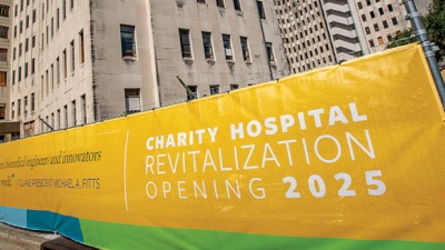 photo of fence covering announcing revitalization of Charity Hospital in 2025