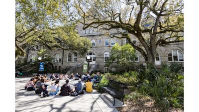 Students sit in class outdoors on the Gibson Quad at Tulane 