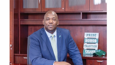 David Harris in a blue suit sitting at a desk