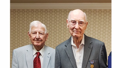 John Barney Taylor (left) and George B. McCullough (right) stand, wearing suits