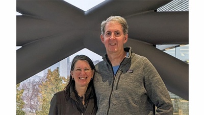 Mark Wheeler and Amelia Archer stand in front of a window