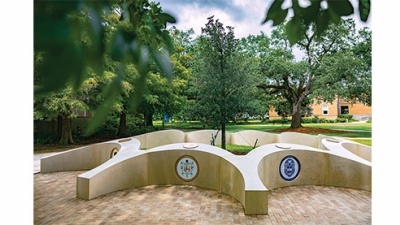 sculptural monument of nine plots nestled among trees 