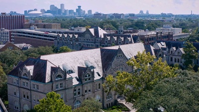 aerial view of Gibson Hall with downtown skyline in the distance