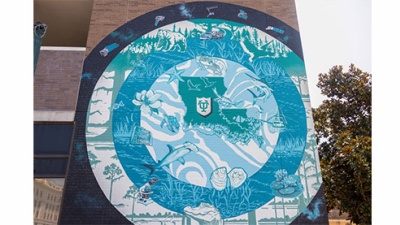 mural in blue, green and white concentric circles with Louisiana animals, plants, and instruments used in science