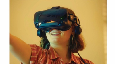 student wearing a VR headset and holding controller up