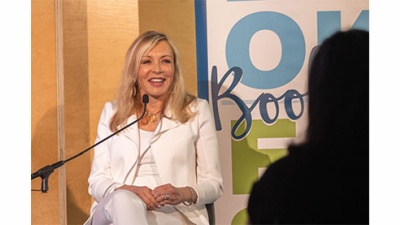 Marie Quintana speaks to audience while seated on the stage at Book Fest