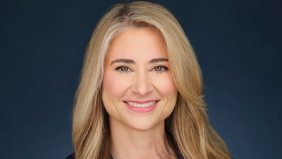 Colette Hirstius TH Portrait of Colette Hirstius. A woman with long, blonde hair smiles warmly against a dark blue background.