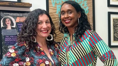 Stephanie Porras and Mia L. Bagneris smile and pose wearing brightly colored patterned clothing