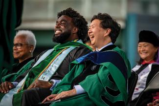 Actor, producer, writer and doctor Ken Jeong and graduate Russell J. Ledet sit on stage.