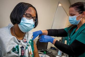 Nurse Giselle Salvant is administered a COVID-19 vaccine