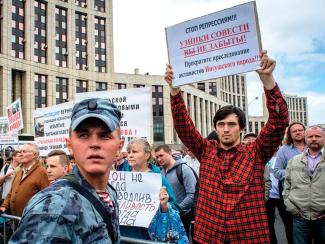 People hold posters during a rally in defense of freedom of speech and journalism in central Moscow on  June 16, 2019.