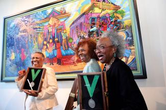 Gloria Bryant Banks, Pearlie Hardin Elloie and Marilyn S. Piper in front of their portrait by Terrance Osborne