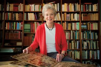 Art historian Elizabeth Hill Boone sits with large open art book