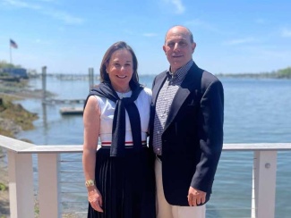 Libby Alexander and Robert Alexander stand in front of a body of water