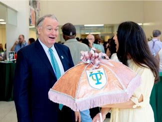 Katherine Andrinopoulos and President Fitts admire the glittered artwork on a second-line umbrella