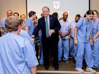 President Fitts shakes hands with members of the Tulane National Primate Research Center's Breeding Colony Team