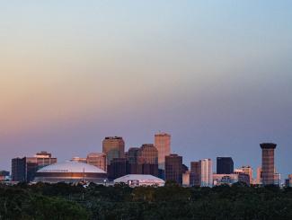 the skyline of downtown New Orleans at sunrise, as seen from the uptown campus