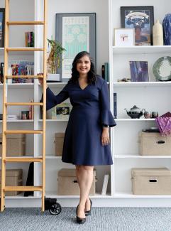 Anita Raj standing next to a library ladder in front of bookcase