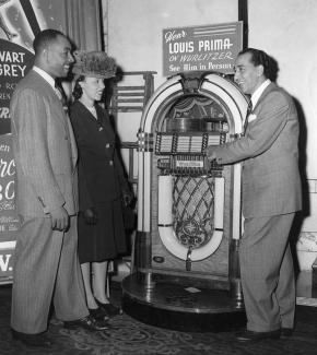 old black and white photo of Prima showing a Wurlitzer jukebox to a man andhttps://library.tulane.edu/tusc woman