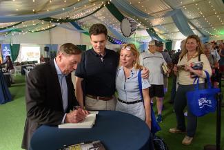 A line of festival-goers wait as General David Petraeus signs a book