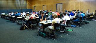 A room in the Lavin-Bernick Center for University Life with many tables of people playing chess.