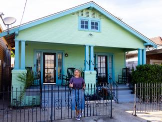 Robin S. Smith in front of light green New Orleans double style house
